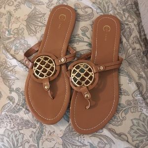 Tan sandals with gold emblem
